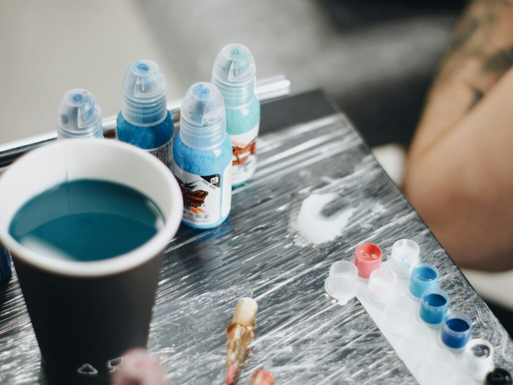 Single use ink caps and a rinse cup at a tattoo station