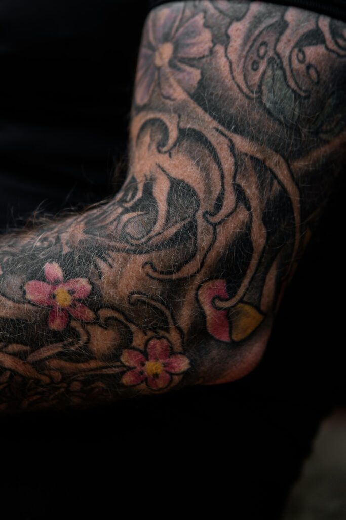 Japanese style sleeve tattoo with cherry blossoms around the elbow