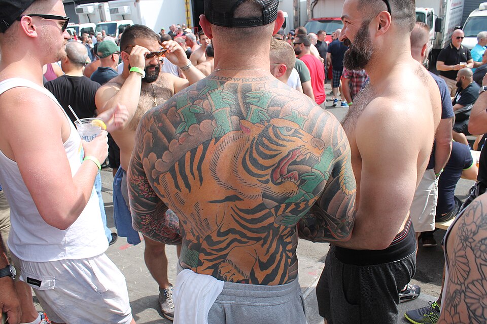 Man with a colorful Japanese style tiger back piece at a tattoo event