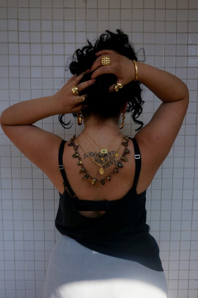 Jewelry style ornamental tattoo on a woman's upper back