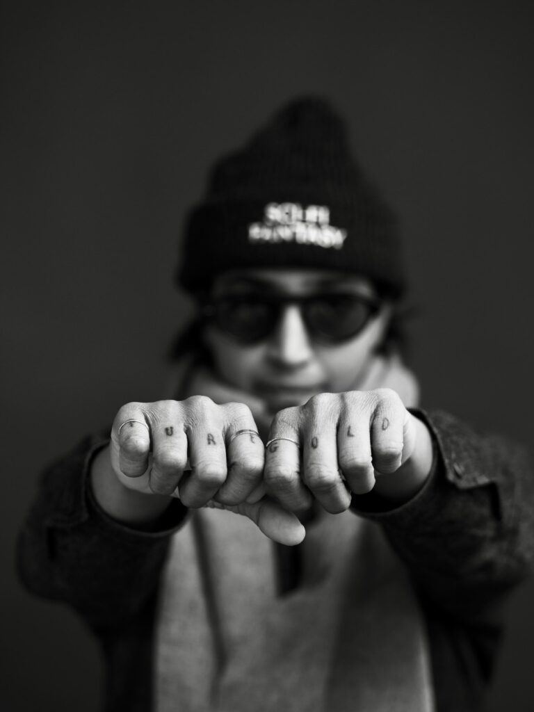 Knuckle lettering tattoo shown on two fists