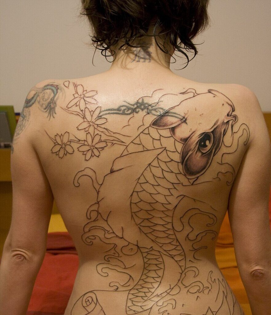 Large koi back piece in outline on a woman