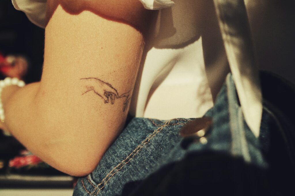 Line art hands tattoo on the inner arm