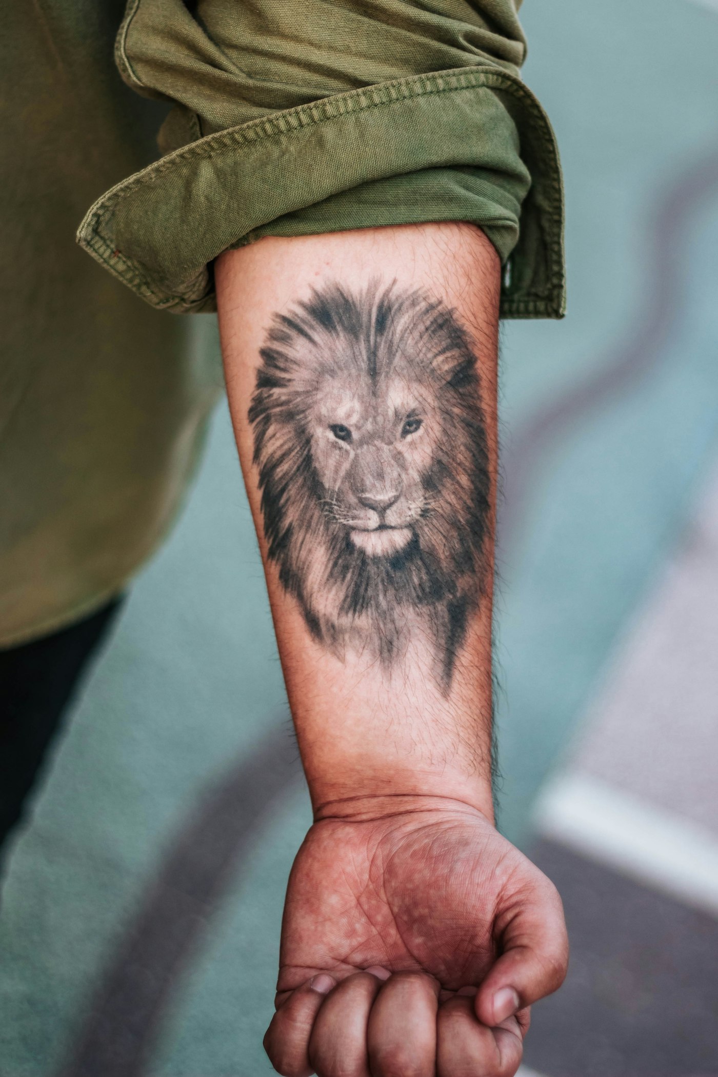 Forearm tattoo ideas for guys: lion tattoo on a man's forearm