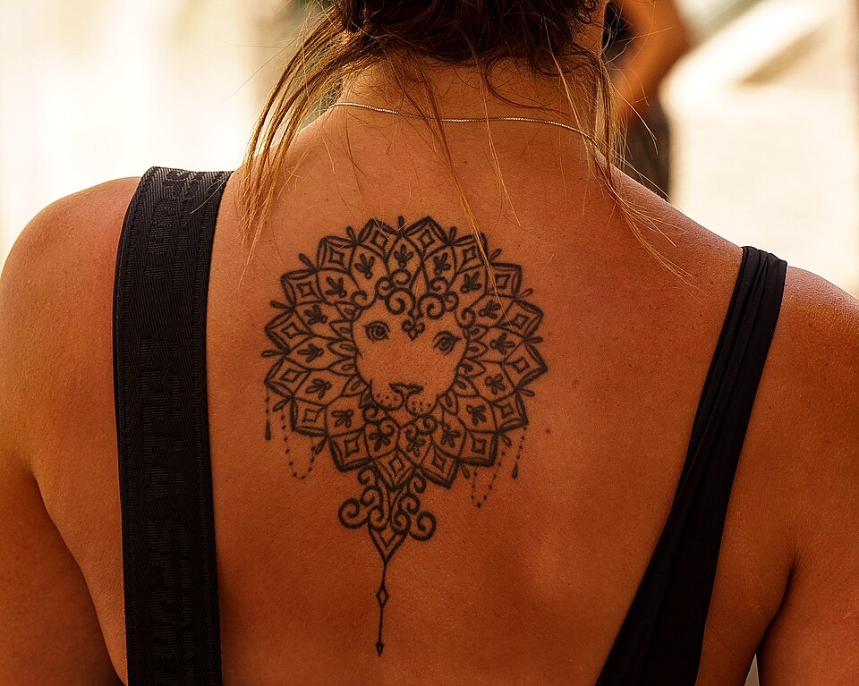 Lion mandala tattoo on a woman's upper back