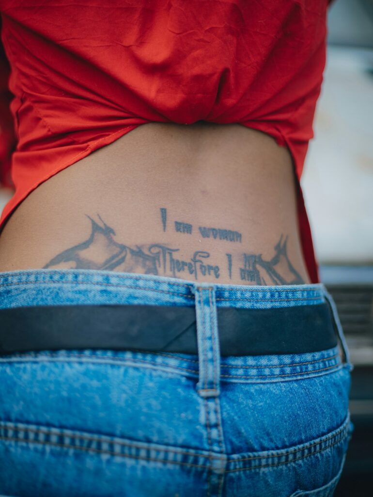Script lettering tattoo on a woman's lower back