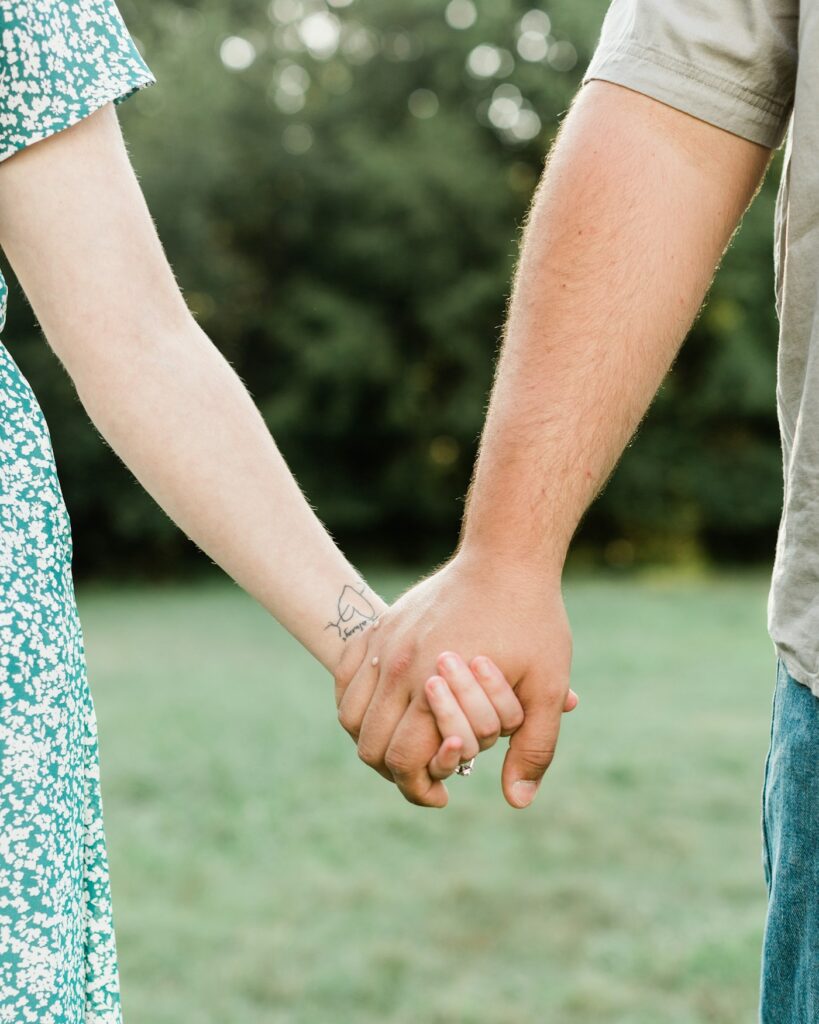 Two people with matching tattoos holding hands