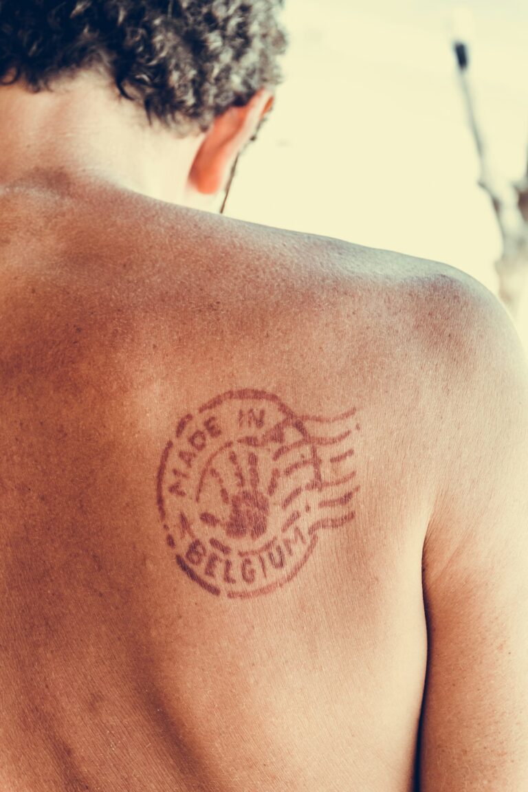 Memorial tattoos: postmark stamp tattoo on the shoulder blade