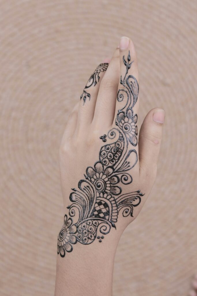 Minimal floral vine henna design on the back of the hand