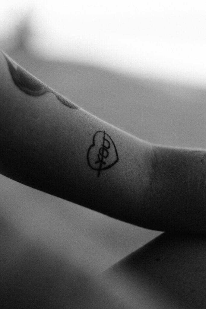 Minimal single line tattoo on the arm in black and white