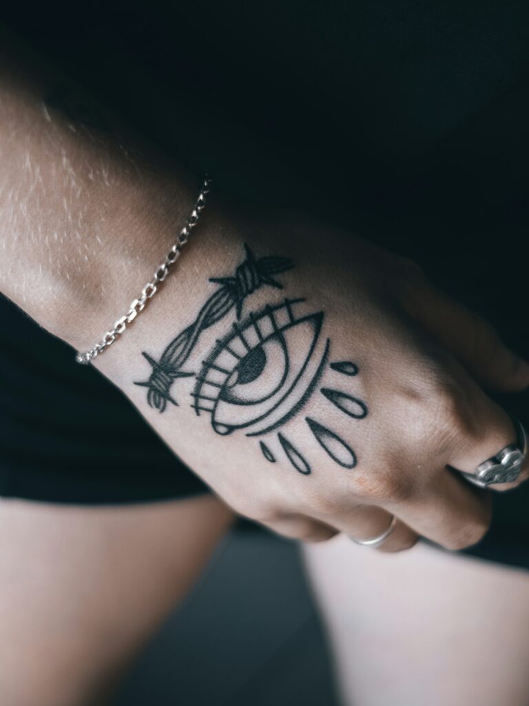 Minimalist black tattoo on the wrist near the hand