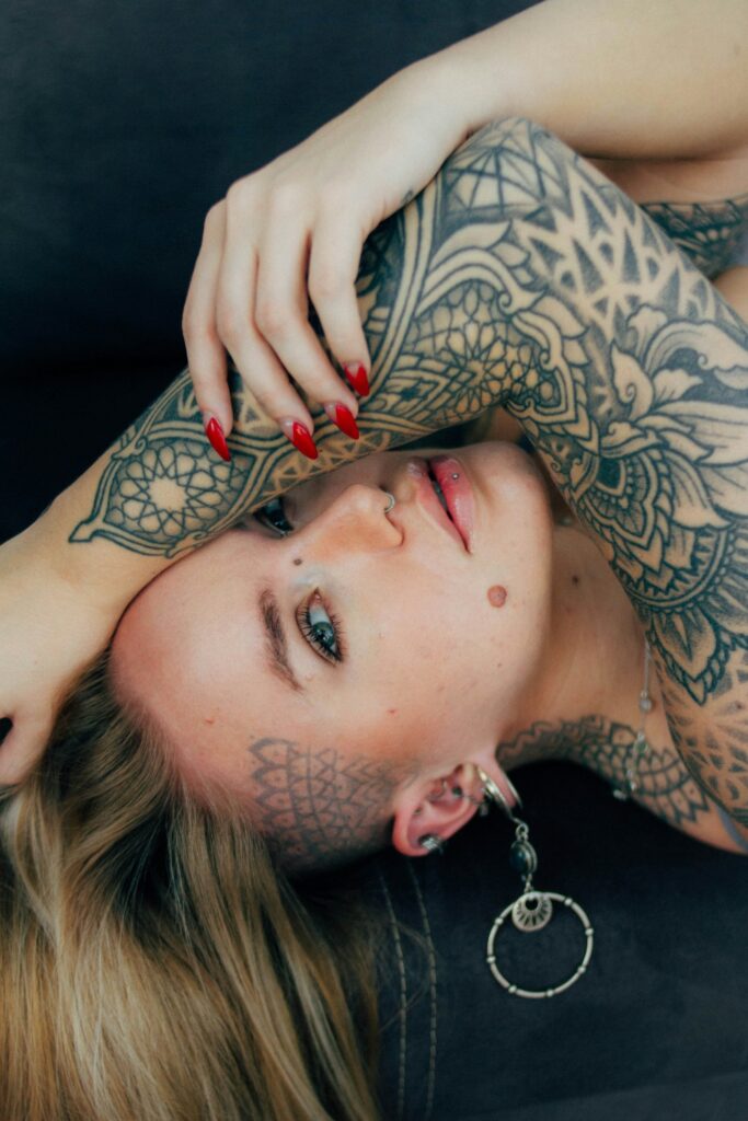 Neck tattoos for women: tattooed woman lying on a sofa