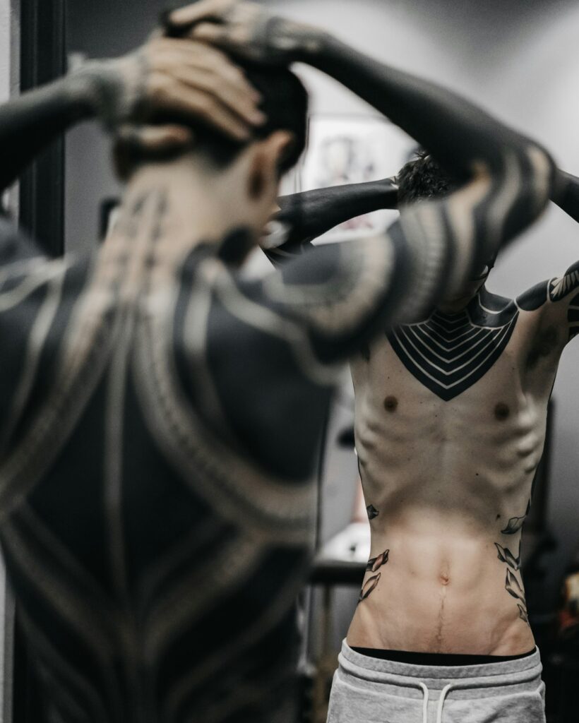 Neo tribal blackwork tattoo across the back and arms
