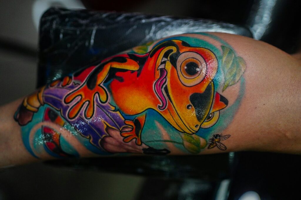 Colorful new school frog tattoo on the arm