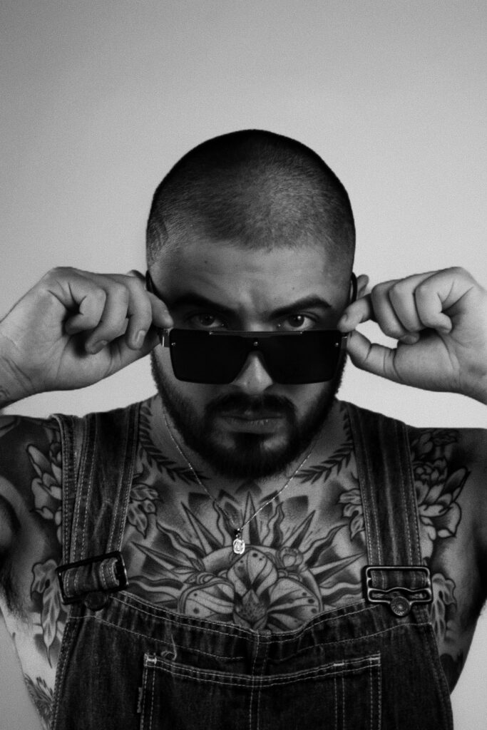 Ornamental chest tattoo on a man in sunglasses