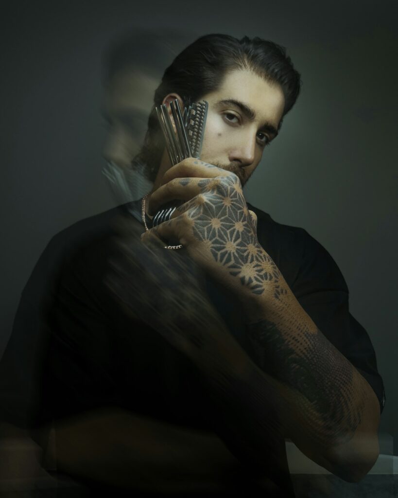 Ornamental black and grey tattoo running over the hand and fingers