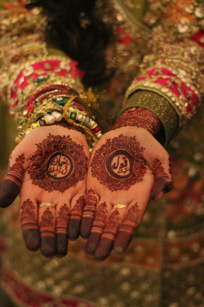 Pakistani bridal henna palms with gold and red bangles