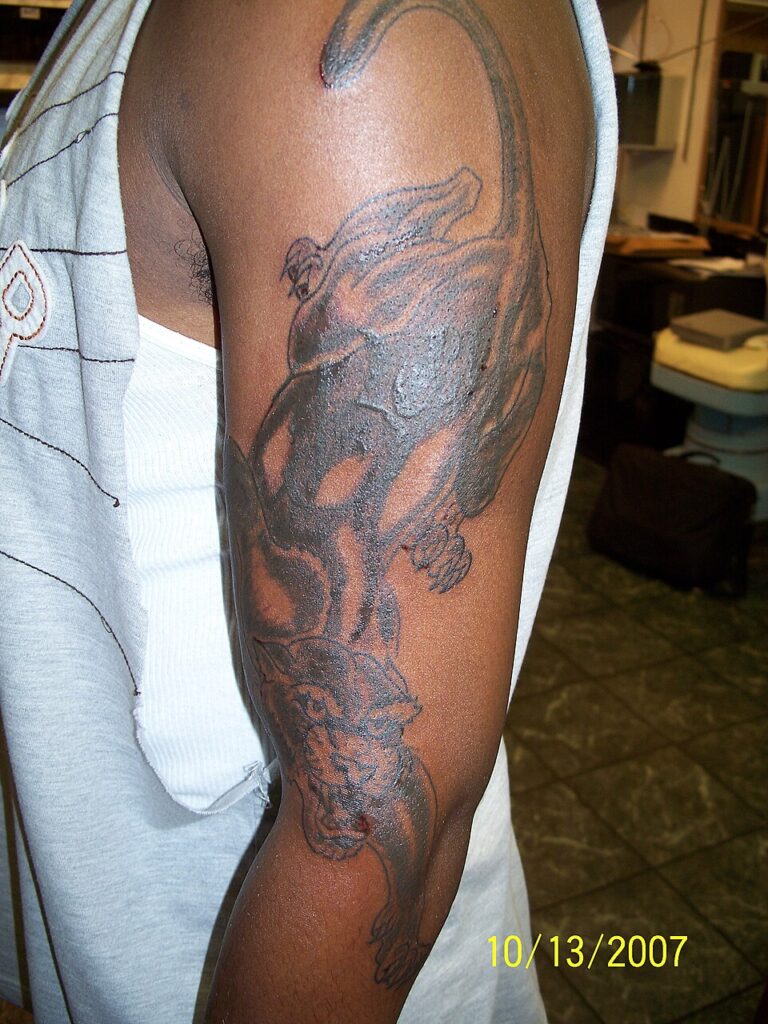 Black panther tattoo used as a cover up on the upper arm