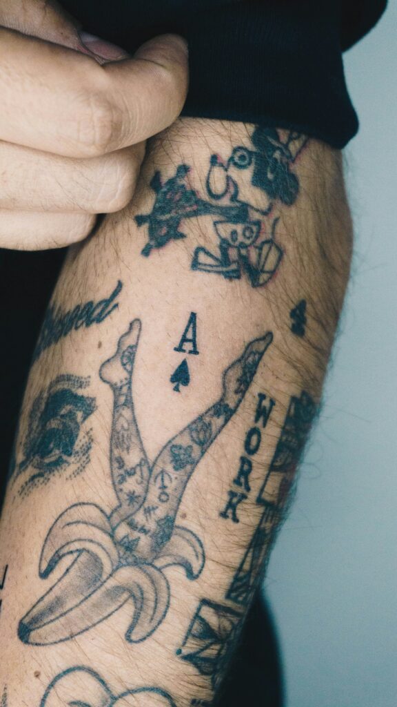 Arm covered in small patchwork tattoos with a hand poked look