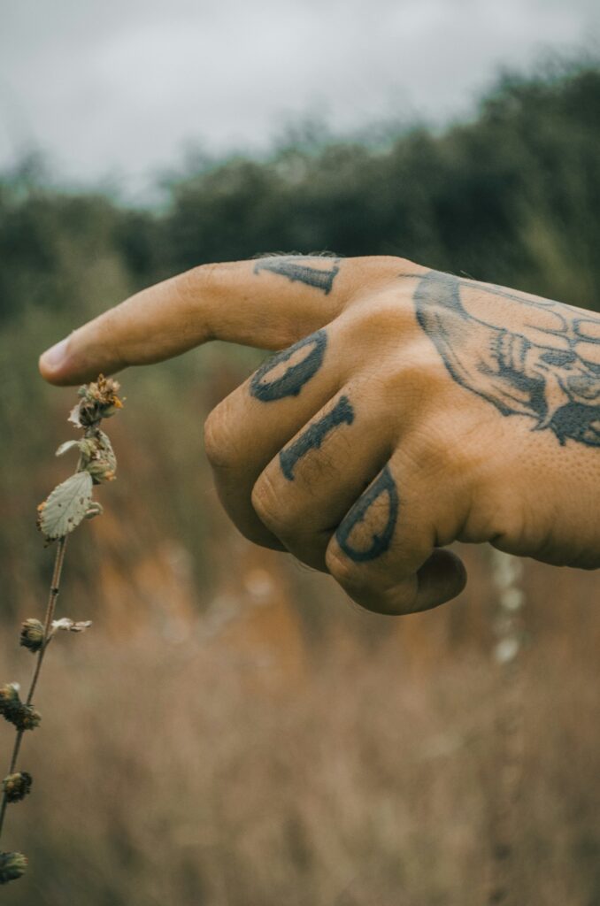 Bold letter tattoos on the fingers of a pointing hand