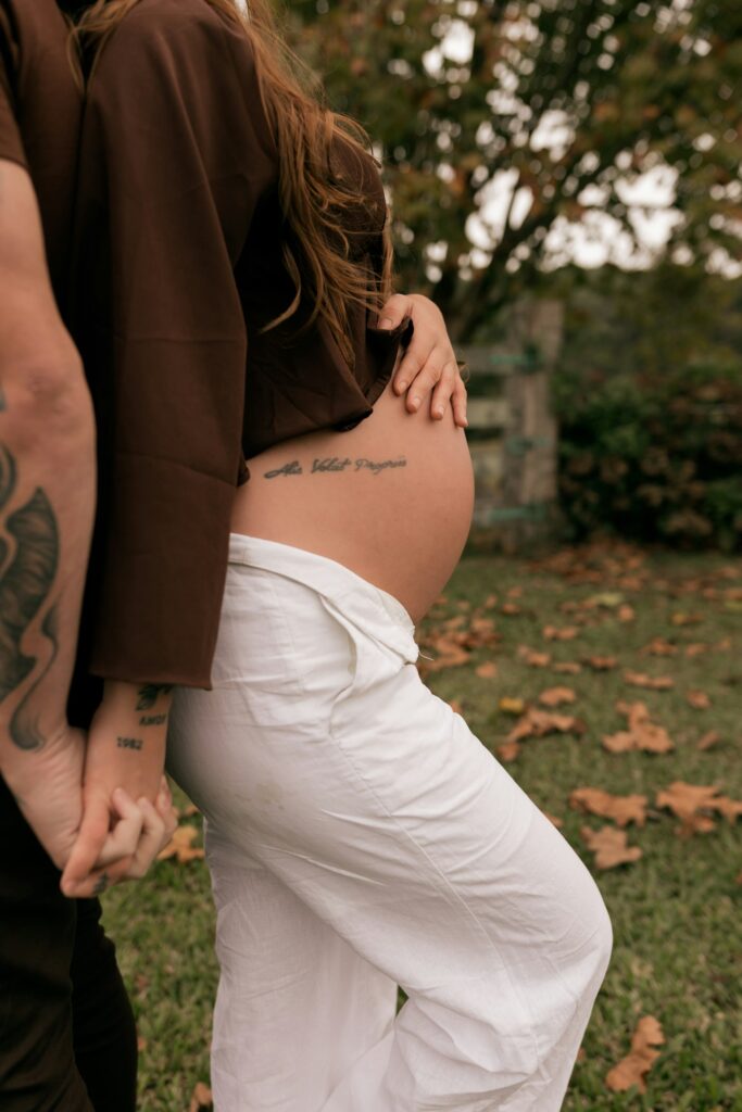 Pregnant woman with a script tattoo on her belly