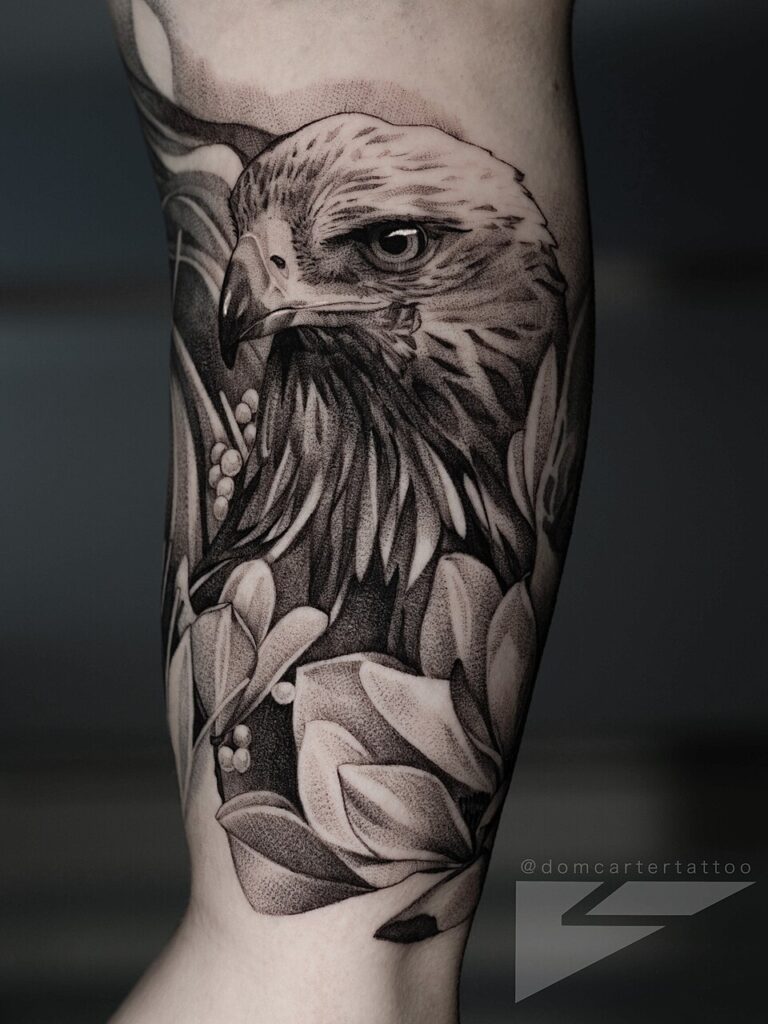 Realistic black and grey eagle head with magnolia flowers on the arm