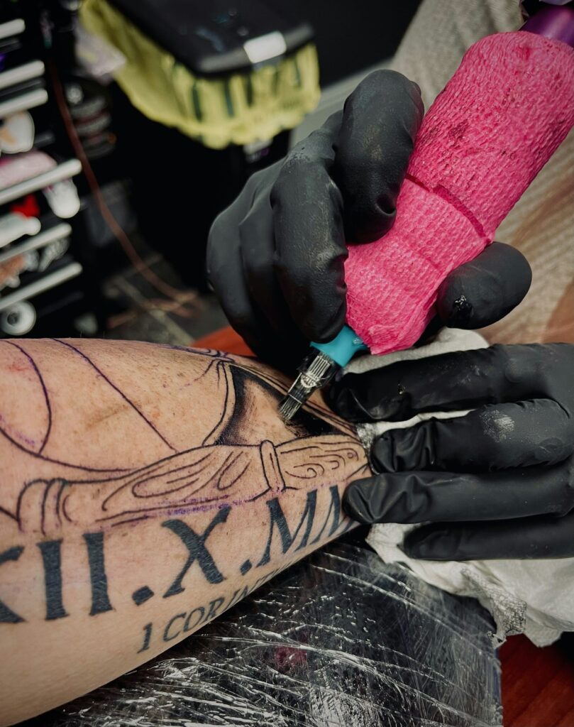Roman numerals date tattoo being inked on the forearm