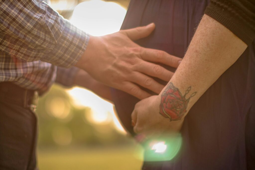Rose tattoo on a hand held by a loved one