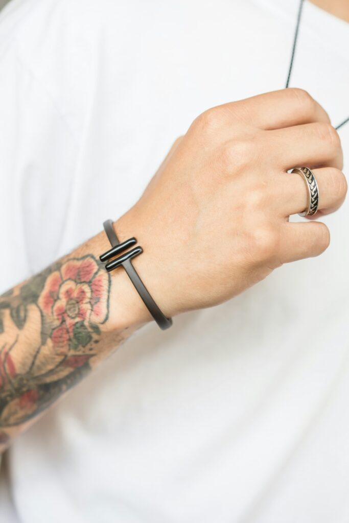 Traditional rose tattoo on the wrist with a cuff bracelet