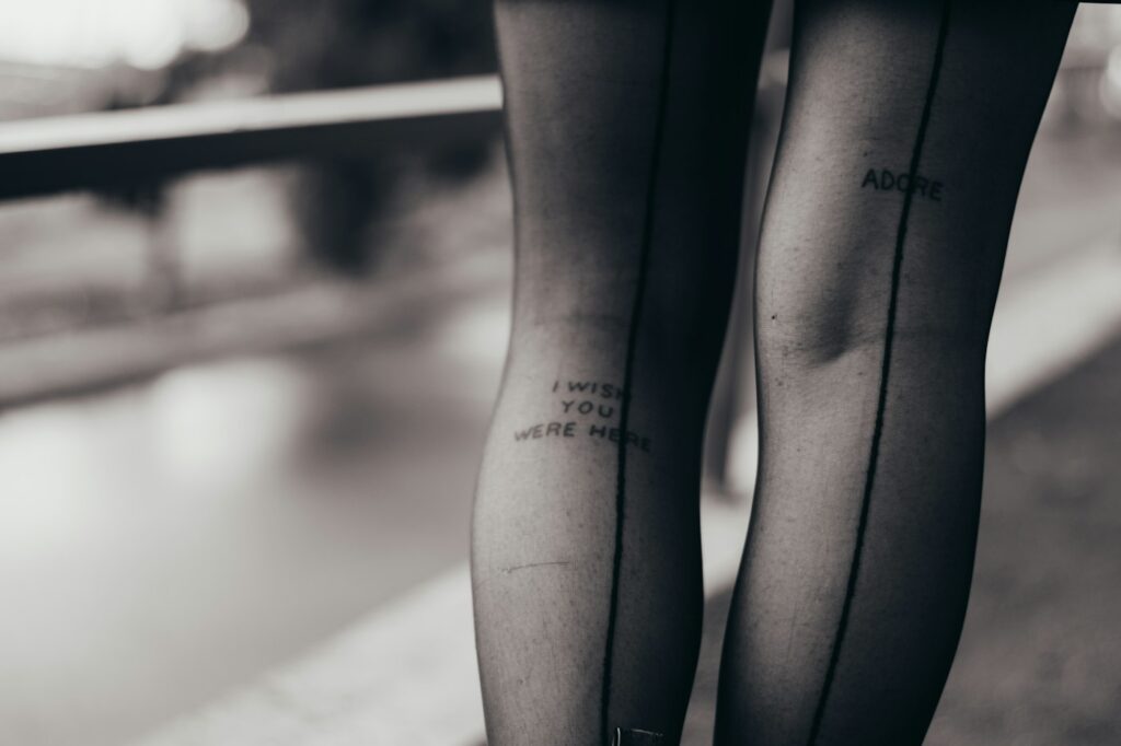 Small script tattoo on the leg under sheer black stockings