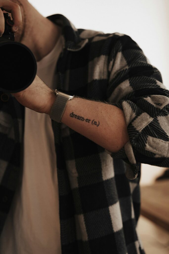Script tattoo on the lower forearm near the wrist