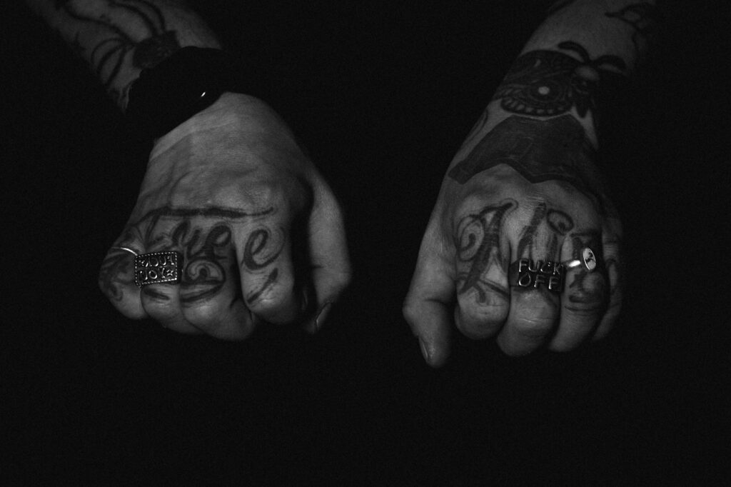 Script tattoos across the backs of both hands