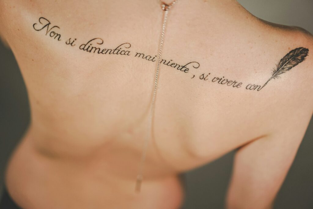 Script quote with a feather across the upper back