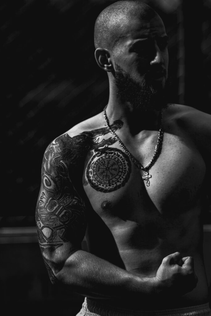 Shoulder cap tattoo connecting to a chest piece on a man