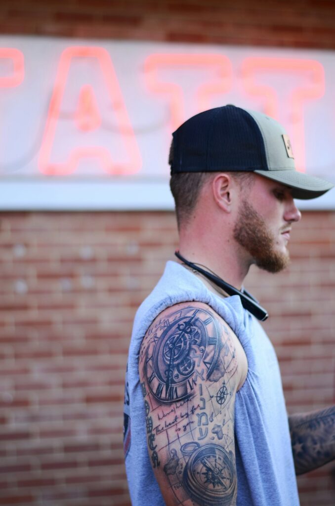 Shoulder cap tattoo on a man wearing a baseball cap