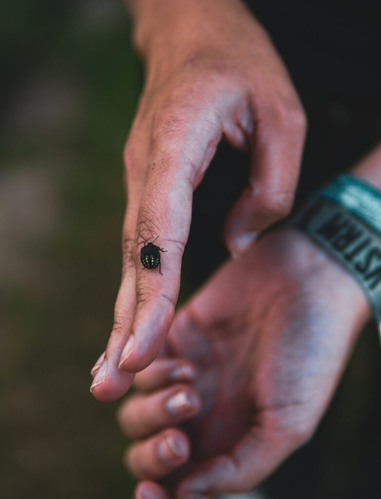 Single small black symbol tattooed on the side of a finger