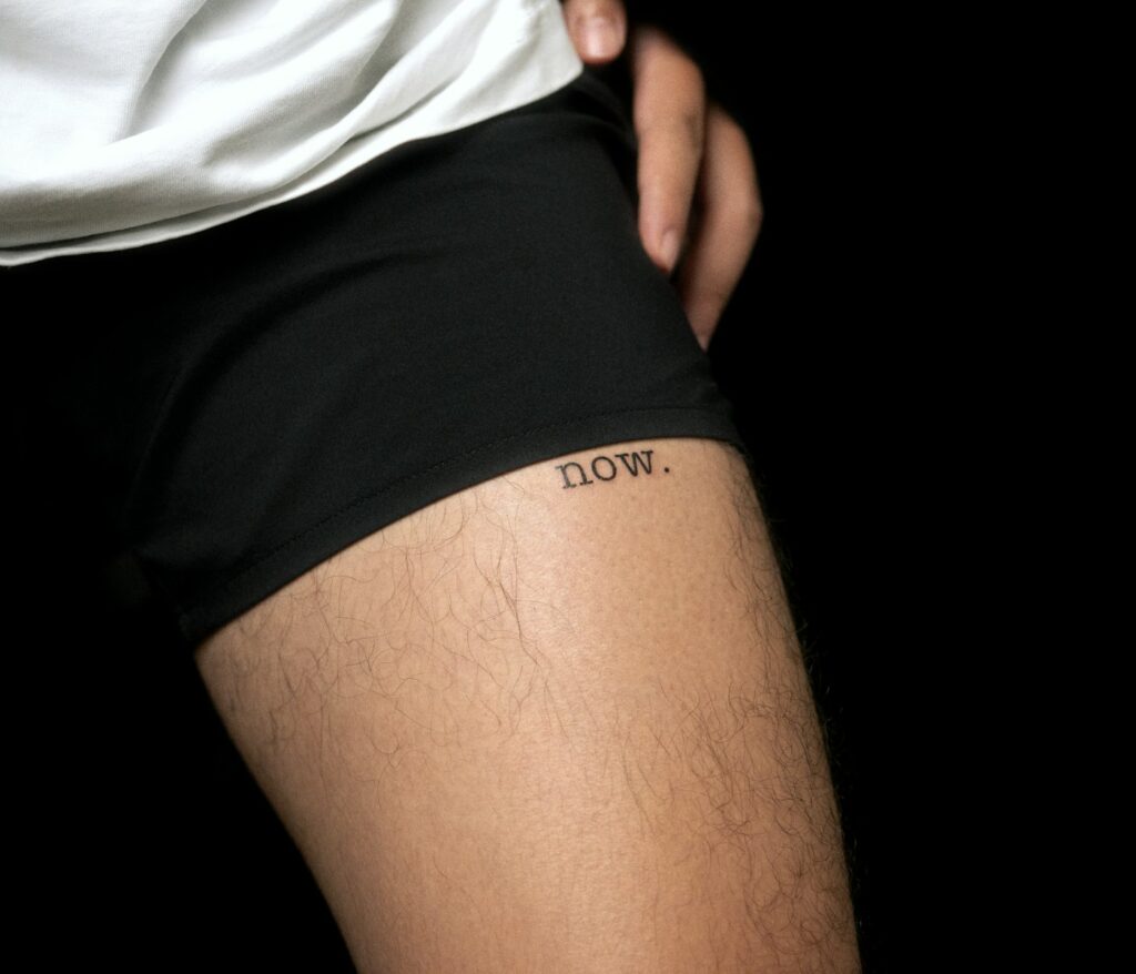 Single word script tattoo on the thigh