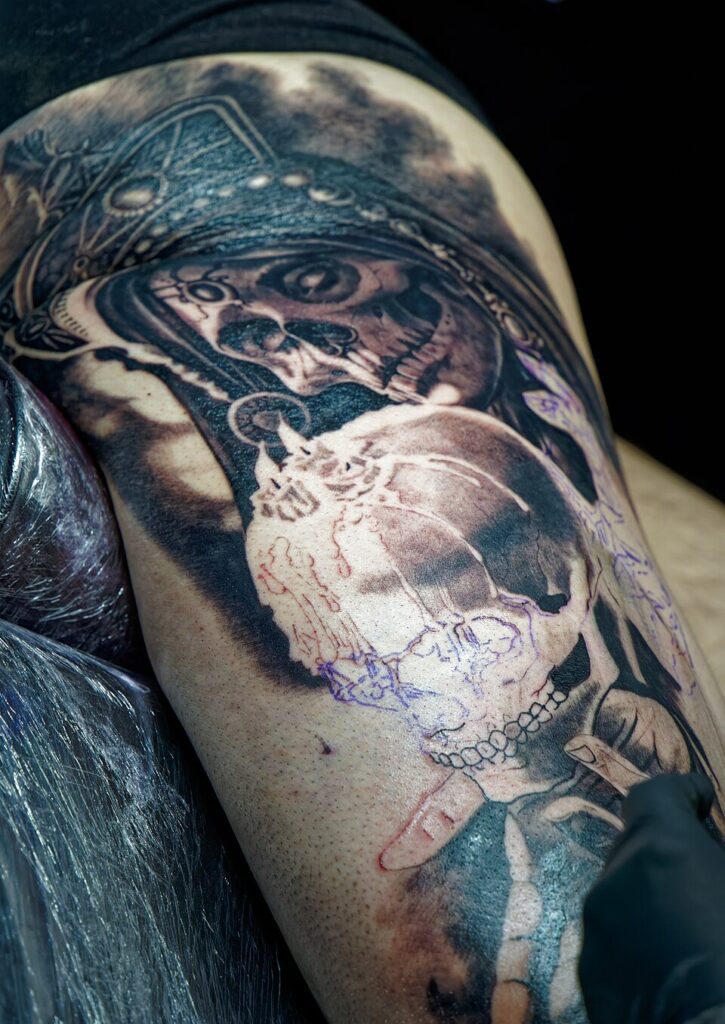 Several skull tattoos on an arm at a tattoo convention