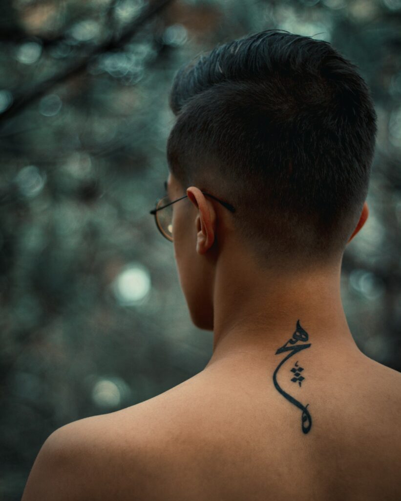 Small symbol tattoo at the back of a man's neck