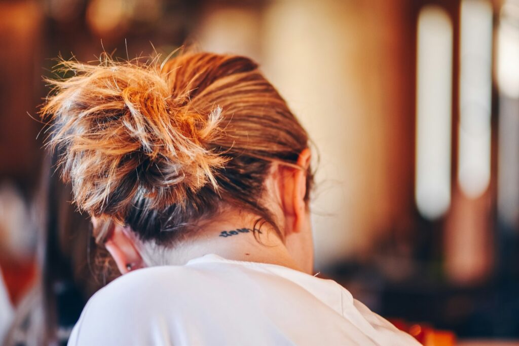 Small tattoo on the nape of a woman's neck