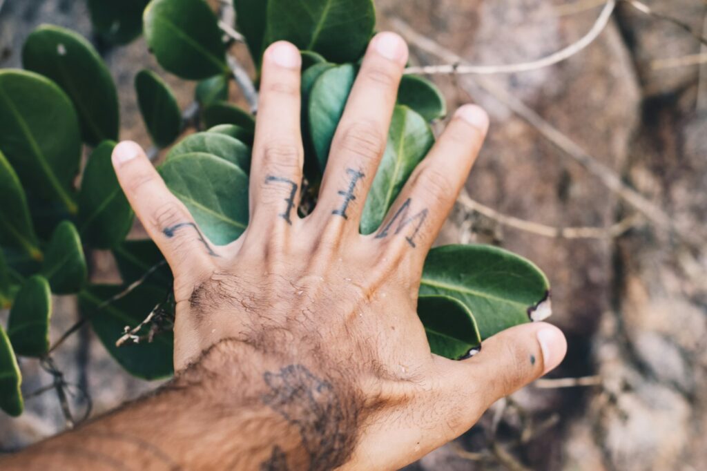 Small script tattoos on the fingers of an open hand