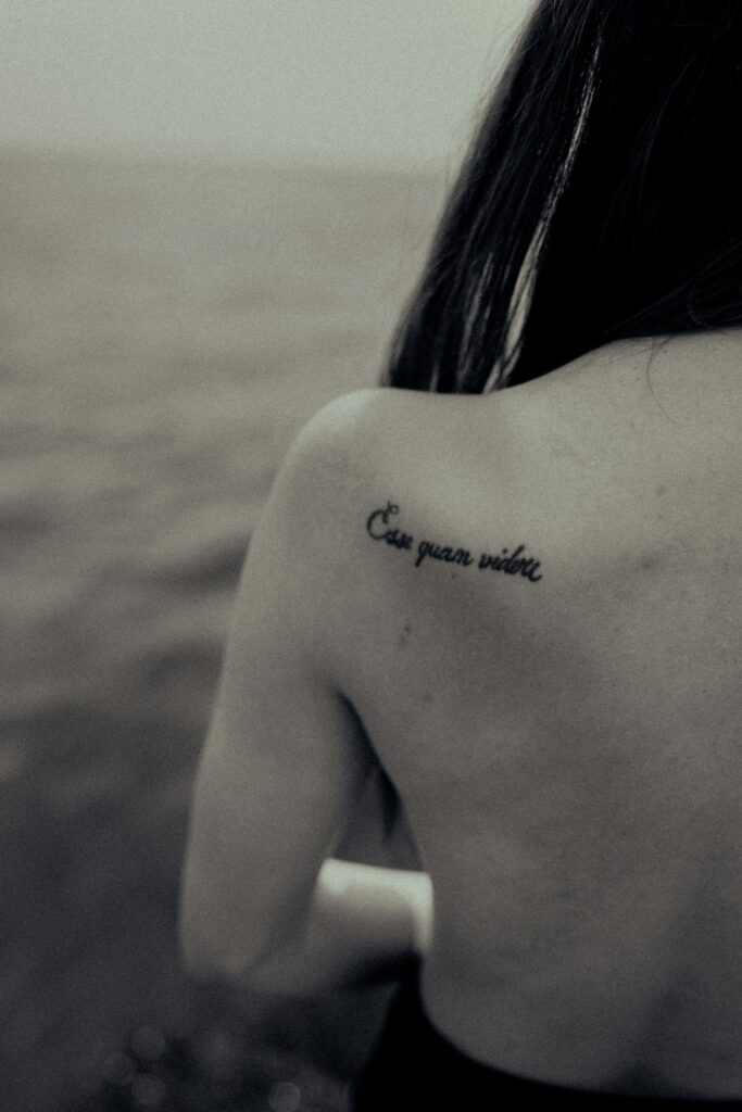 Small script tattoo on the shoulder blade