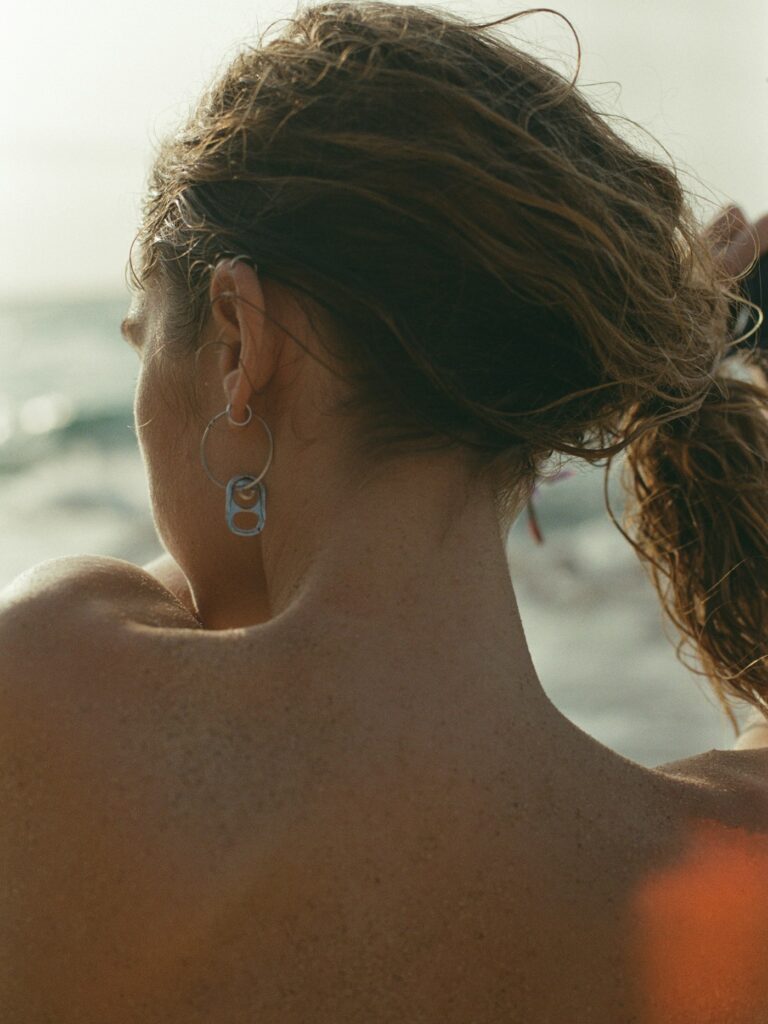 Small symbol tattoo on the side of a woman's neck