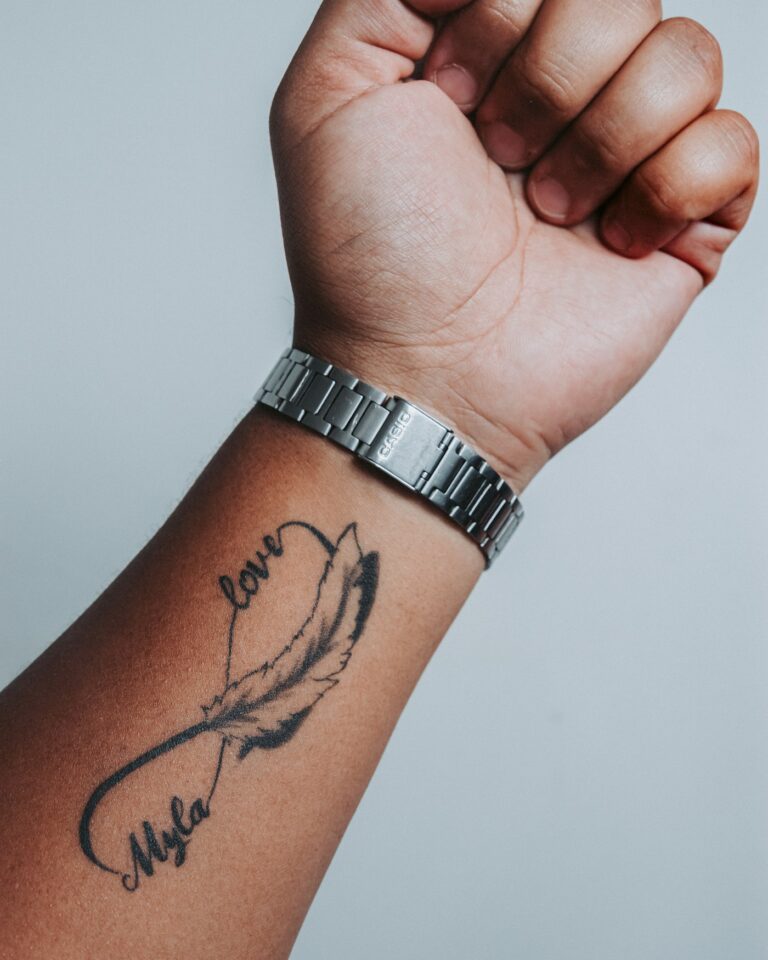 Small tattoo ideas: script and feather tattoo on the wrist