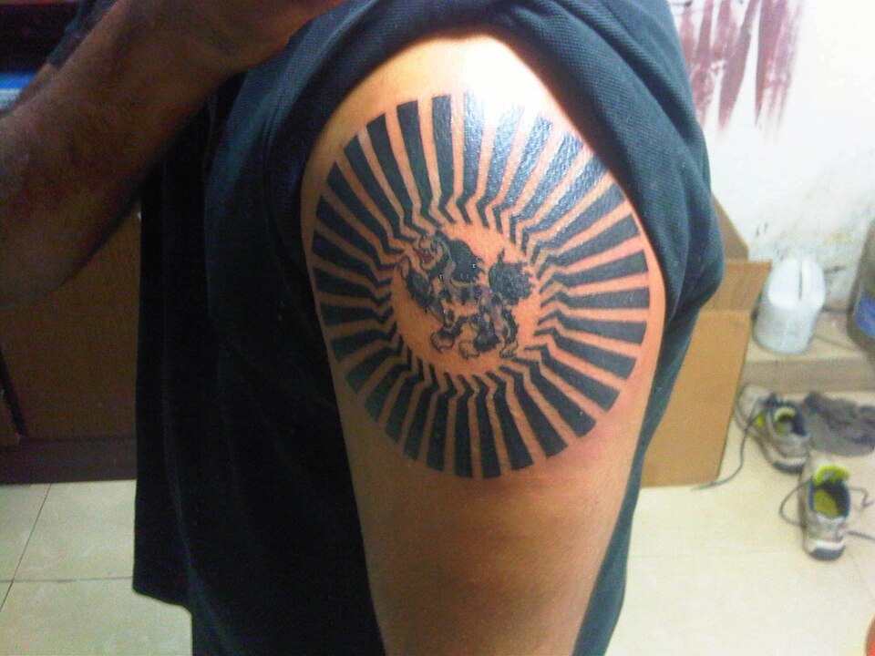 Snow lion inside a rising sun tattoo on the shoulder
