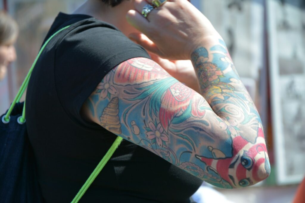Soft color floral sleeve tattoo on the arm