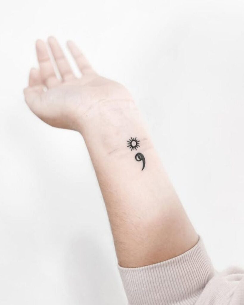 Semicolon tattoo with a sun on the inner wrist