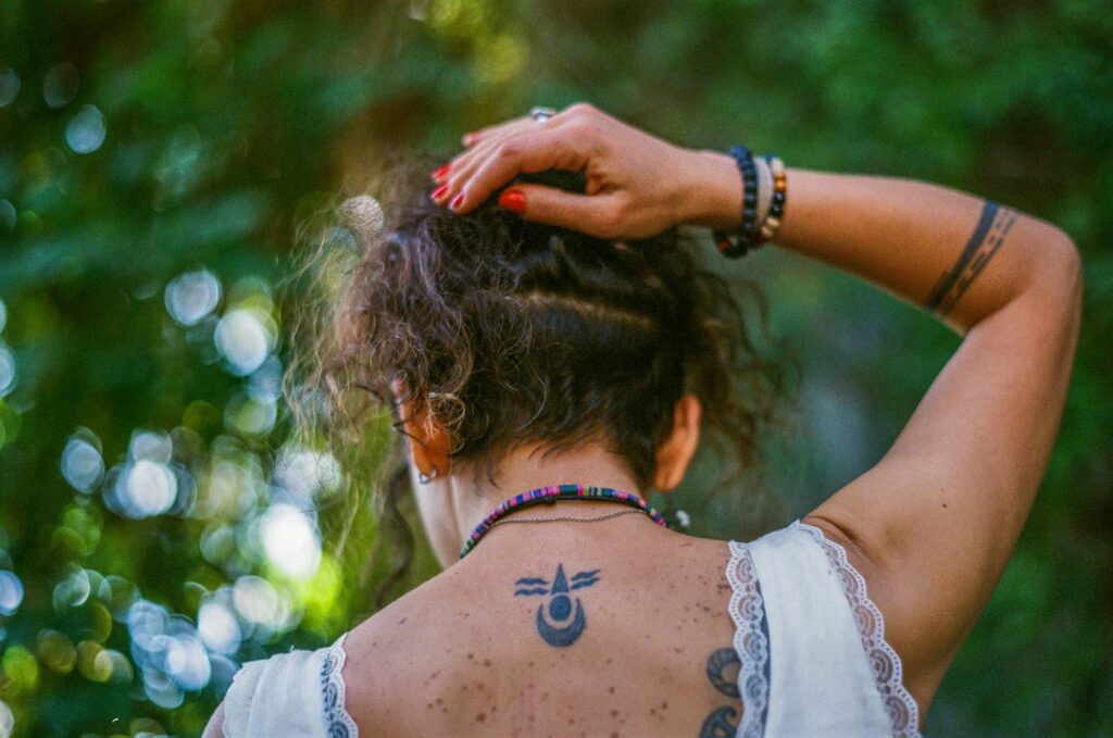 Symbol tattoo below the nape of a woman's neck
