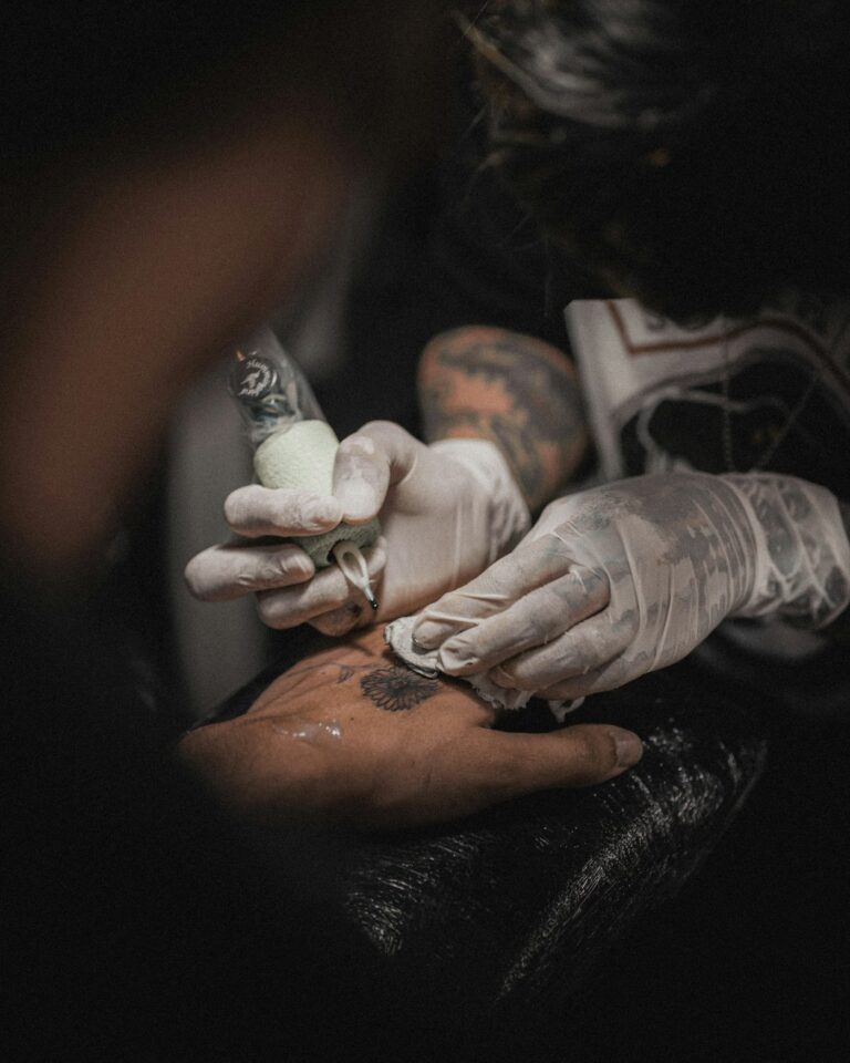 Tattoo aftercare: artist in gloves caring for a fresh tattoo