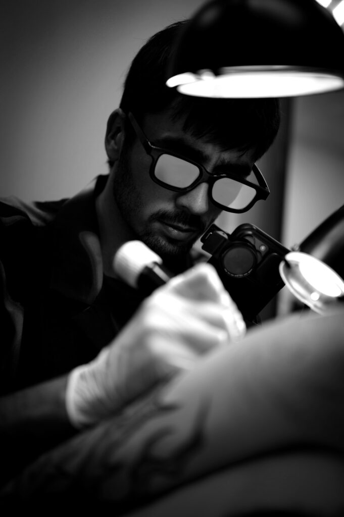 Tattoo artist wearing magnifying glasses for detailed work